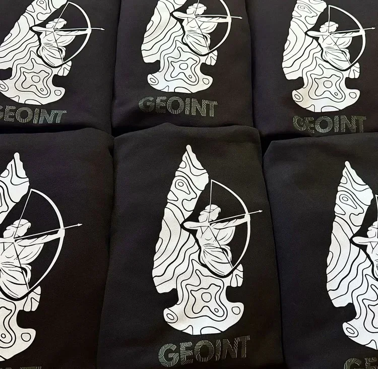 Folded stack from a bulk run of DTF-printed hoodies showing consistent full-color detail