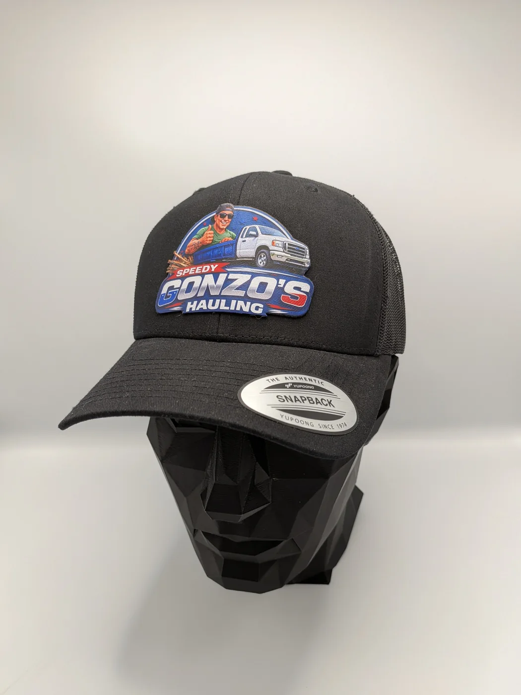 Trucker cap with a full-color printed fabric patch heat-applied to the front panel