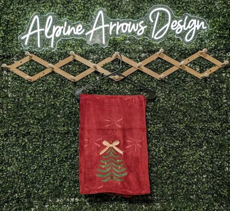 Embroidered Christmas tree and bow on a red holiday hand towel