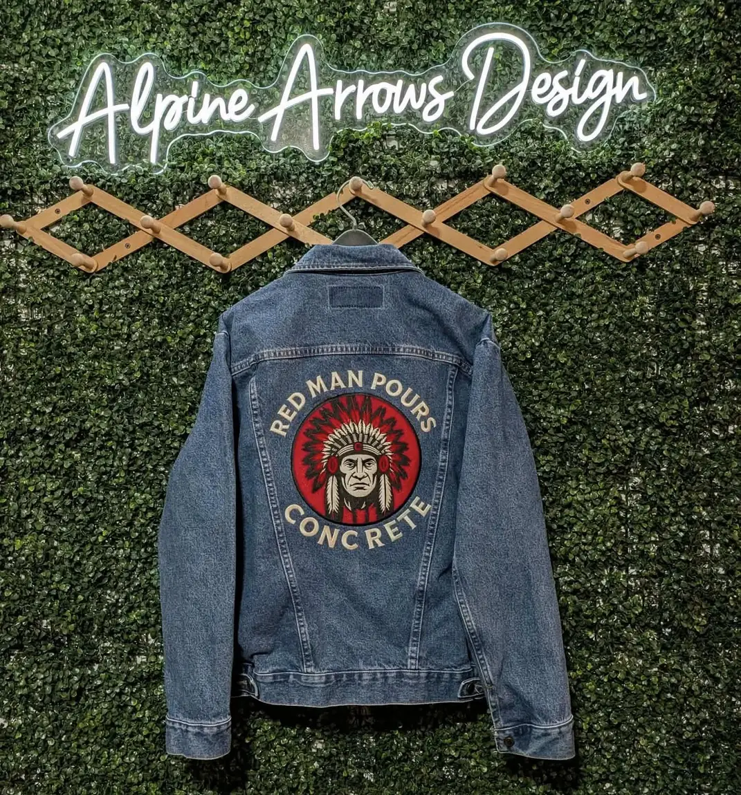 Denim jacket with a large circular embroidered logo across the back