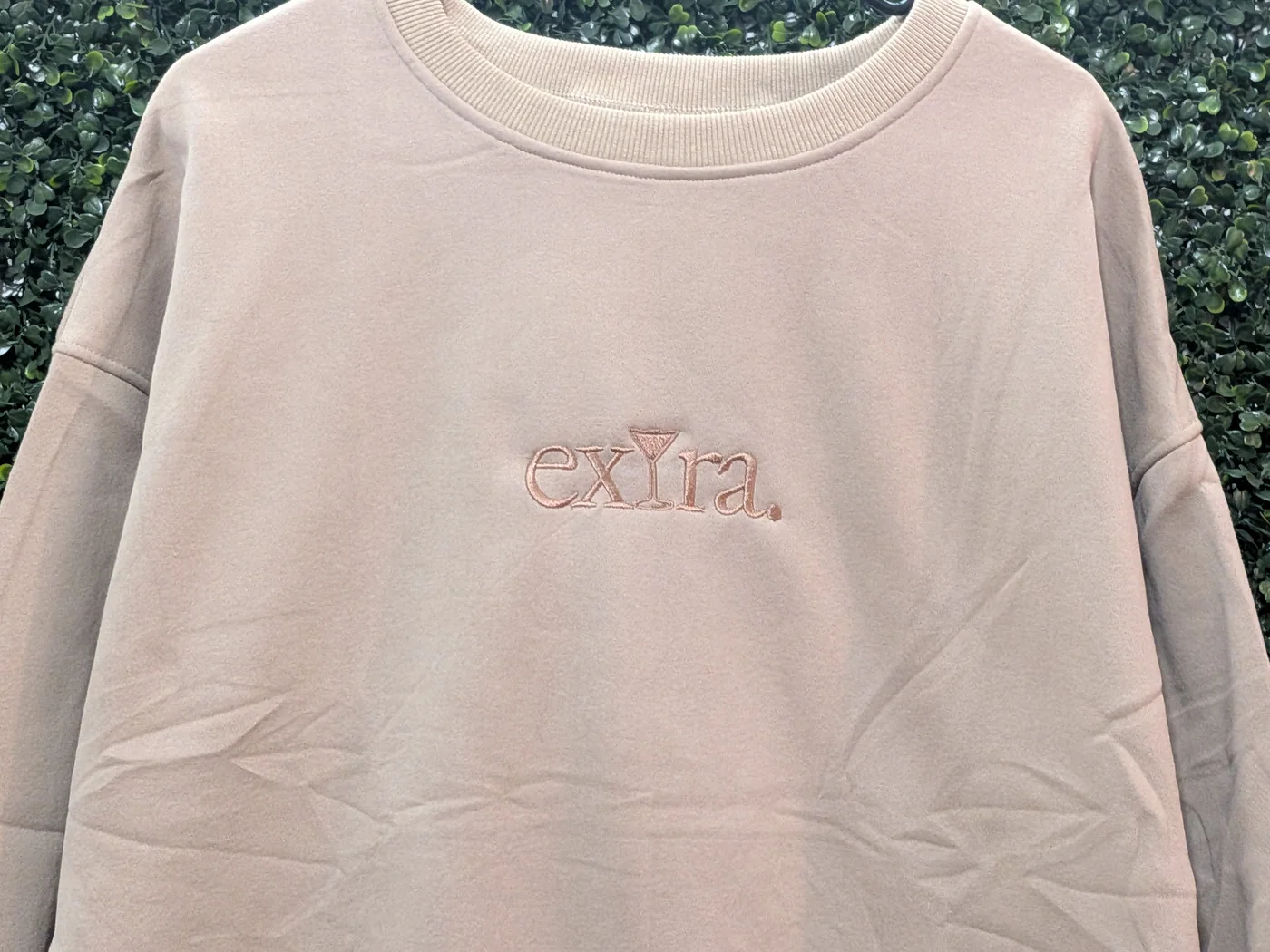 Tone-on-tone embroidered lettering on a tan crewneck sweatshirt