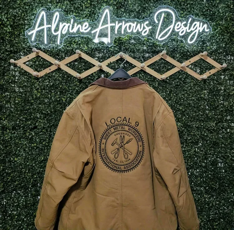 Tan canvas work jacket with a large embroidered trade union emblem on the back