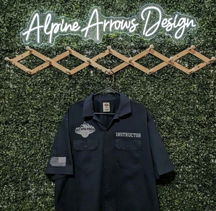 Navy work shirt with an embroidered trade union emblem, a name panel and an American flag sleeve patch